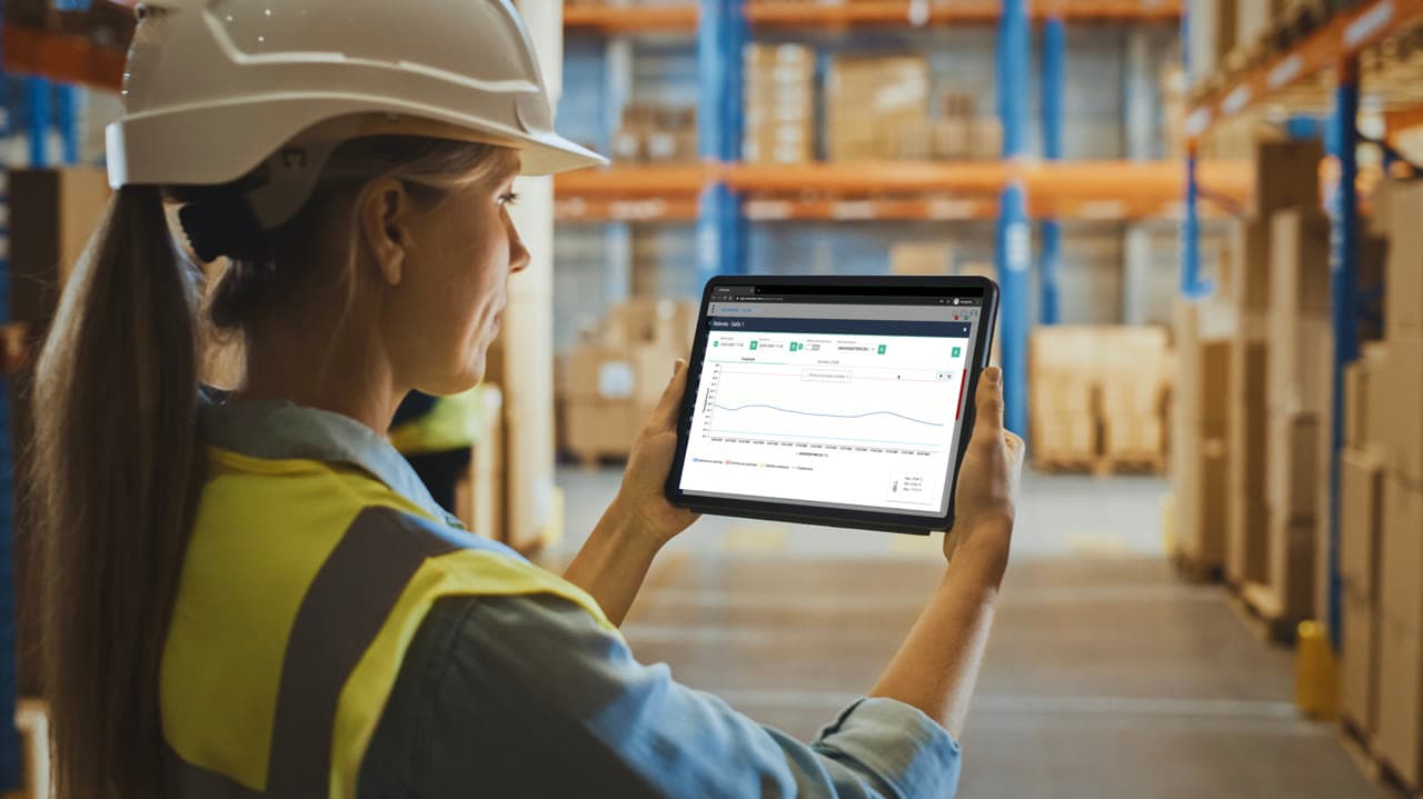 Warehouse worker checking Dickson OCEAView environmental monitoring data on a tablet in a cold chain distribution centre