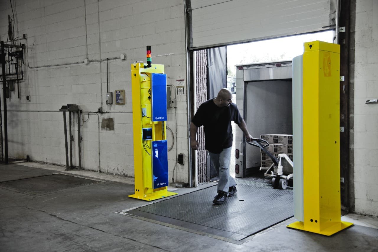 Zebra FX9500 RFID portal at a warehouse dock door automatically reading tagged pallets as they pass through